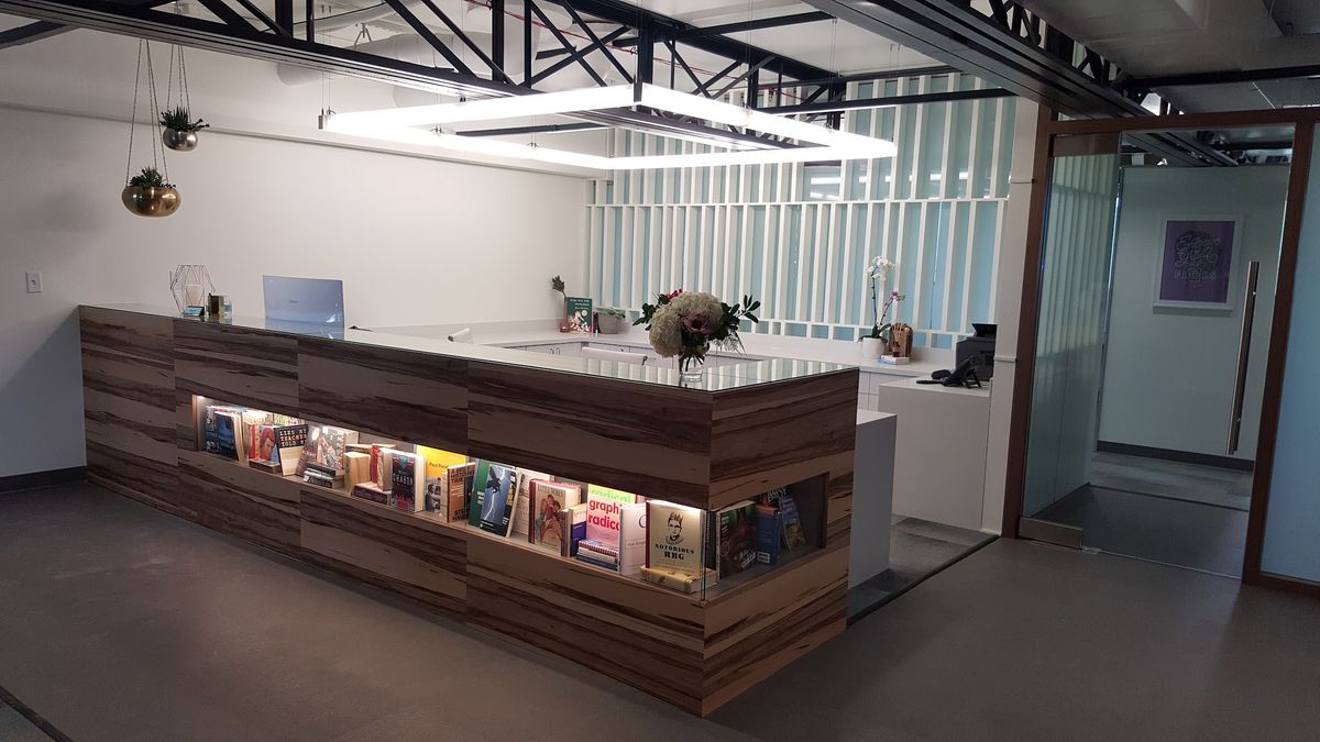 Wood-front reception desk with built-in display by J&M Custom Cabinet Shop